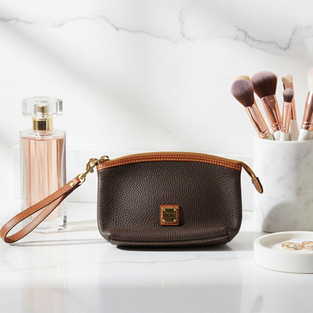 Brown leather handbag with a gold zipper and clasp on a white background