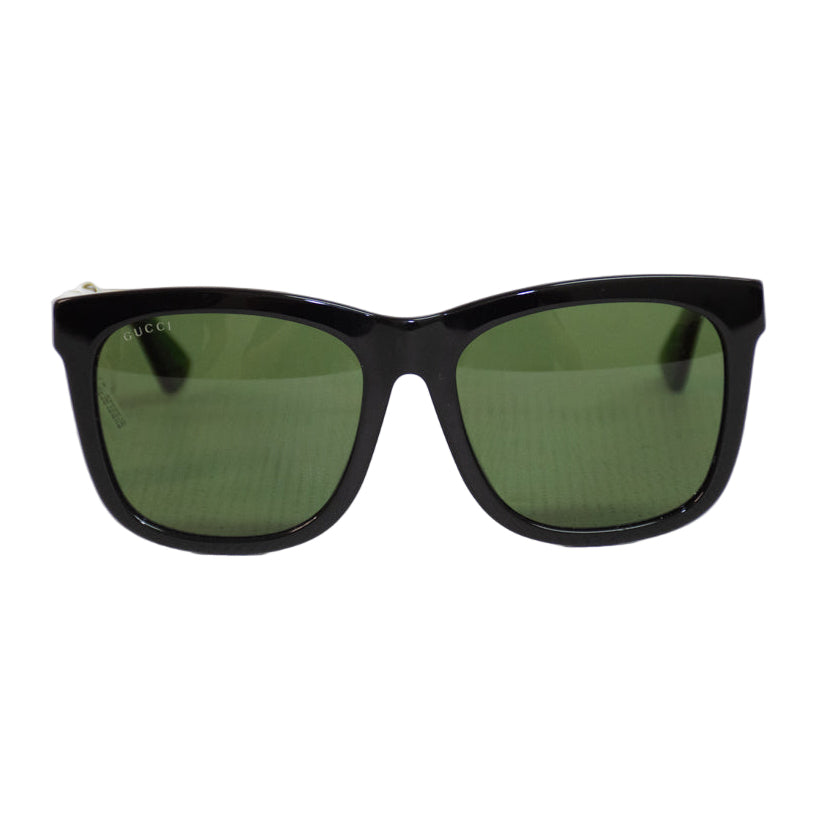 Black sunglasses with green lenses on a white background